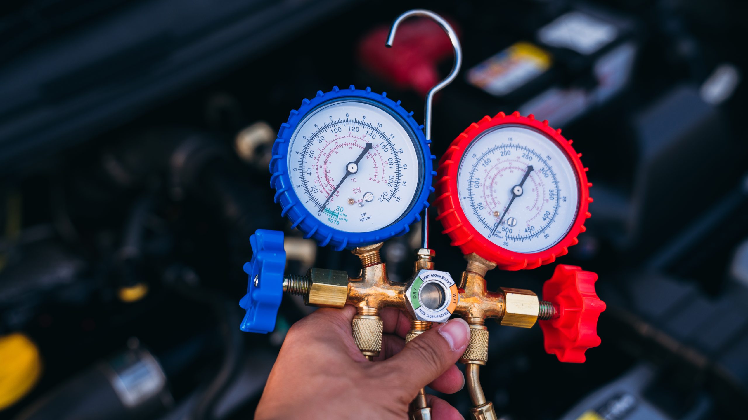 Close up hand of Mechanics inspect and check the refrigerant and fill the car air conditioner