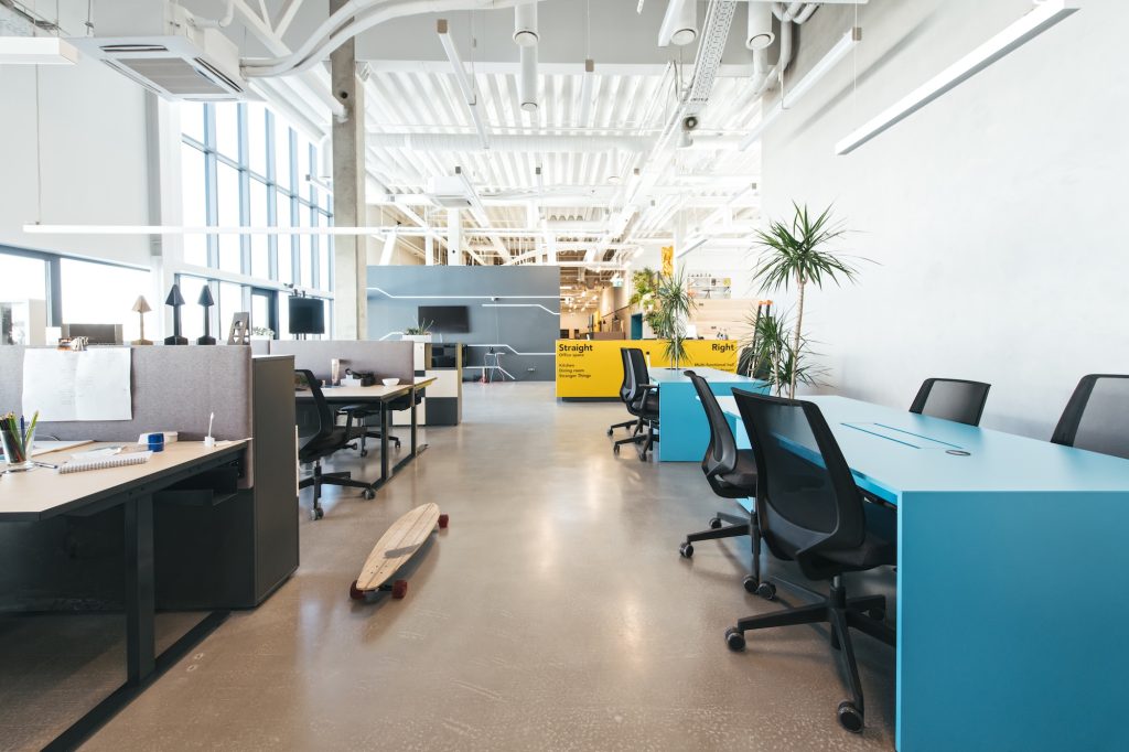 Inside shot of new stylish open space office with contemporary design and high ceiling in daylight